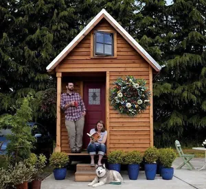 Detailansicht eines Herbstkranzes mit bunten Kürbissen und Eukalyptus an einer Hütte
