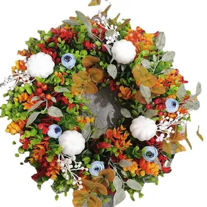 Farbenfroher Herbstkranz mit Eukalyptusblättern, weißen Kürbissen und blauen Beeren