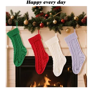 Set of four cable knit Christmas stockings in red, green, white, and purple colors.