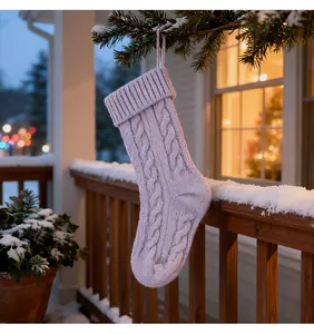 Detailed view of a lavender cable-knit Christmas stocking hanging on a snowy pine branch