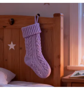 Detailed view of a lavender cable-knit Christmas stocking hanging on a wooden bed
