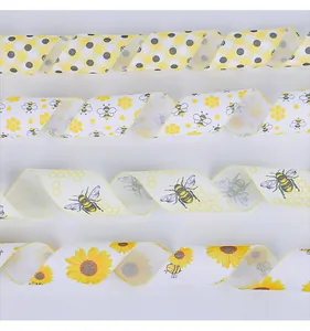 Close-up of assorted bee and sunflower themed decorative ribbons on white background