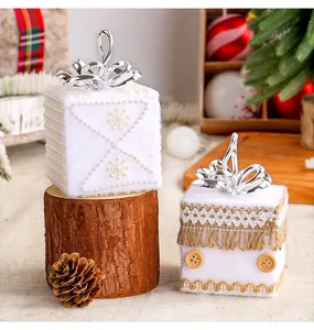 Détail d'ornements de boîte cadeau de Noël en mousse blanche avec corde et dentelle.
