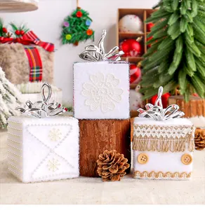 Gros plan sur les boîtes cadeaux de Noël en mousse avec dentelle et perles blanches.
