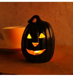 Detailed view of glowing black Halloween pumpkin lantern on wooden table for party decoration