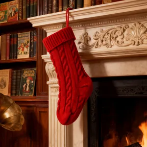 Festive red cable-knit Christmas stocking hanging on a warm cozy fireplace mantel.