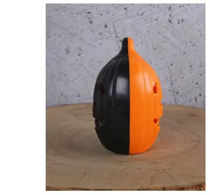 Close-up of black and orange two-tone Halloween pumpkin lantern on wooden base decor