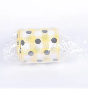 Close-up of yellow and white checkered ribbon with black polka dots in plastic wrap