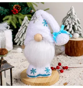 Vista dettagliata di uno gnomo natalizio in peluche bianco con ricami di fiocchi blu