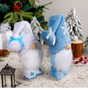 Dettaglio di gnomi di Natale in peluche con motivi a fiocchi di neve e fiocchi sulla neve.