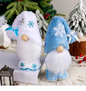Gnomi di Natale in peluche con cappelli a fiocco di neve su sfondo festivo innevato