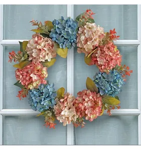 Detailed view of realistic blue and pink artificial hydrangea wreath on a window