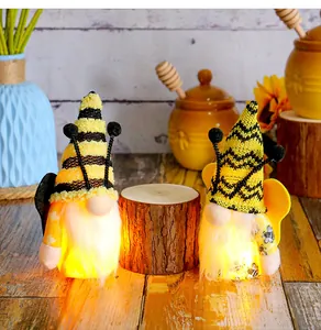 Detailed view of two cute glowing bee festival gnomes with yellow wings and lights