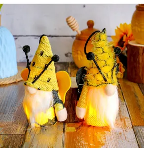 Close-up of two glowing bumblebee gnomes with yellow wings for spring festival decor