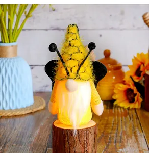 Detailed view of glowing bee-themed gnome with wings on a wooden stump decoration