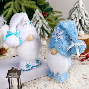 Gnomi natalizi di peluche con ricami a fiocco di neve in una scena di festa