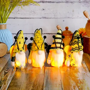 Set of four plush honey bee festival gnomes with internal LED lights on wooden table