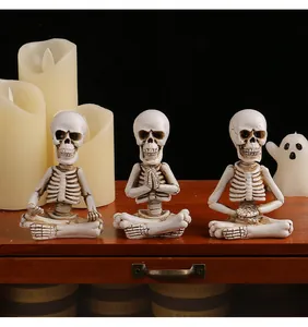 Vue détaillée de trois figurines de squelette en résine en poses de méditation pour Halloween