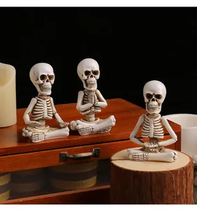 Vue détaillée de trois figurines de squelettes en méditation sur des surfaces en bois