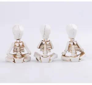 Vue détaillée montrant le dos de trois figurines de squelette de yoga en résine.