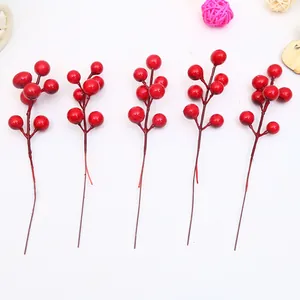 Cinco tallos de bayas rojas vibrantes para decorar el árbol de Navidad sobre fondo blanco.