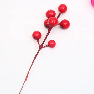 Primer plano de un tallo de bayas rojas artificiales para decoración navideña festiva