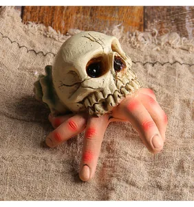 Detailed view of Halloween resin skull with creepy red-knuckled fingers ornament