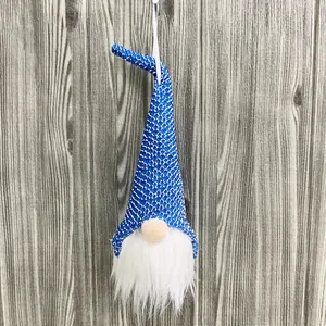 Handmade Nordic Christmas gnome hanging on a wooden background for holiday home decor