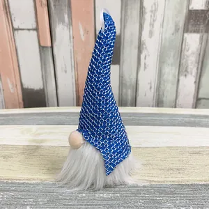 Handmade Christmas gnome featuring a tall blue knitted hat and a soft white beard detail.