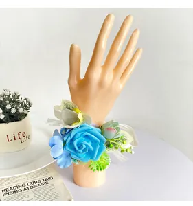 Detailansicht einer handgefertigten blauen Rosen-Corsage für Brautjungfern an einer Hand