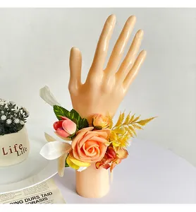 Detailansicht einer handgefertigten Brautjungfer-Handgelenksrose mit orangefarbenen Blüten.