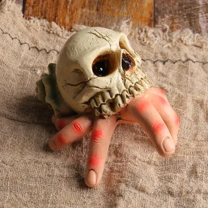 Realistic resin horror ornament featuring a skull on a hand for Halloween courtyard decor.