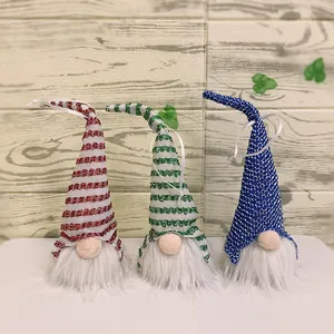 Detail of three Nordic Christmas gnomes with striped hats and long white fur beards
