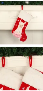 Detailed view of red Christmas stocking with alpaca design and pink tutu on a mantel.