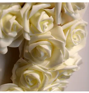 Close-up macro view of delicate white foam rose petals on a romantic heart-shaped wreath.