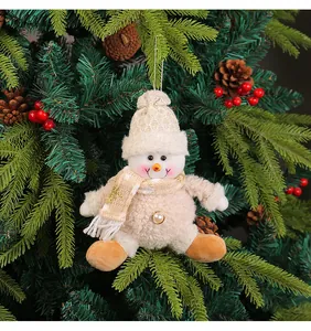 Dettaglio di un pupazzo di neve in peluche color crema su un albero di Natale