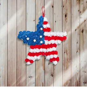 Patriotic July 4th star wreath with red, white, and blue PU flowers on wooden wall