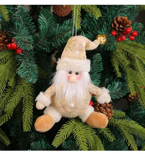 Dettaglio di Babbo Natale in peluche oro champagne appeso all'albero di Natale.
