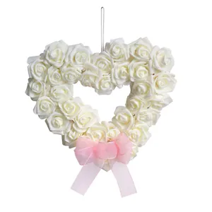 Romantic heart-shaped wreath with white foam roses and a delicate pink ribbon bow