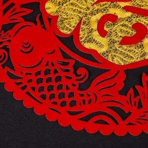 Macro detail of red non-woven Chinese New Year Fu sticker with hollowed golden carp