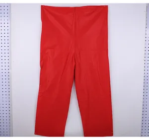 Détail du pantalon de costume de Père Noël en tissu non tissé rouge pour Noël.