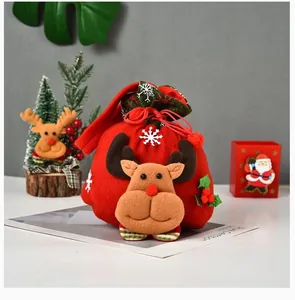 Primer plano de una bolsa de regalo de Navidad roja con cabeza de reno de peluche 3D.