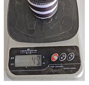 Close-up showing the precise weight measurement of a roll of black and white striped ribbon