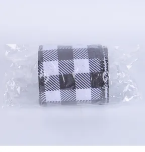 Close-up of a roll of black and white checkered buffalo plaid ribbon in plastic wrap