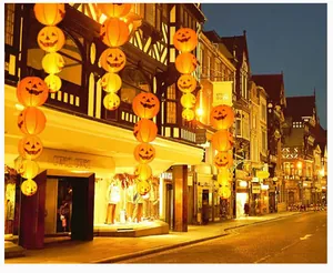 Vista notturna con diverse lanterne a zucca luminose in un ambiente stradale europeo.