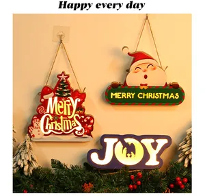 Detailed view of glowing wooden Christmas hanging ornaments on a wall with pine decor
