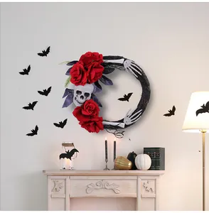 Griezelige Halloween krans met schedel en rode rozen op een witte open haard decor