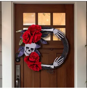 Gedetailleerd zicht op een Halloween-krans met schedel en rode rozen op een houten deur.