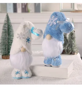 Zwei Plüsch-Weihnachtswichtel mit blau-weißer Schneeflocken-Stickerei im Detail