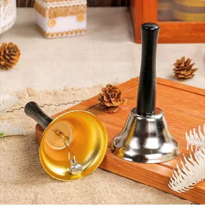 Detail view of decorative gold and silver Christmas handbells with black wooden handles.
